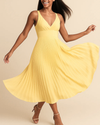 The Soleil pleated midi dress in butter yellow, made from sustainable recycled polyester. Shown from the front view. Ethically made in London by ADKN