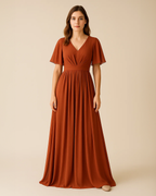 Terra Maxi Dress with flutter sleeves in burnt orange, crafted from recycled polyester chiffon. Vegan, ethical fashion for bridesmaids or wedding guest. Ethically made by ADKN in London